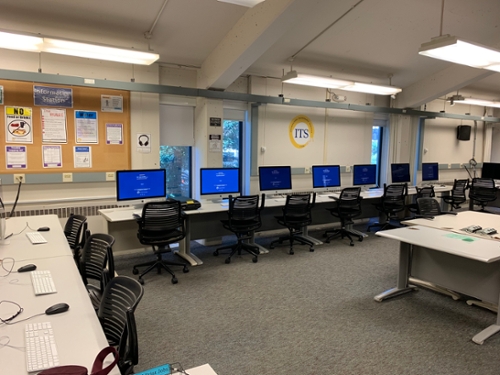 Rows of chairs, mac computers, and a whiteboard in the porter arts lab