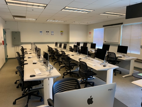 Rows of mac computers and wheeled chairs in the College 8 lab